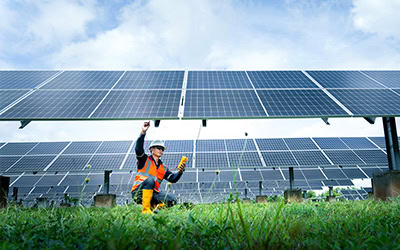 Engineer inspecting solar panel with tools and devices.