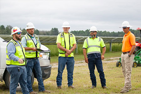 Engineers huddled for a meeting at a solar site before an inspection