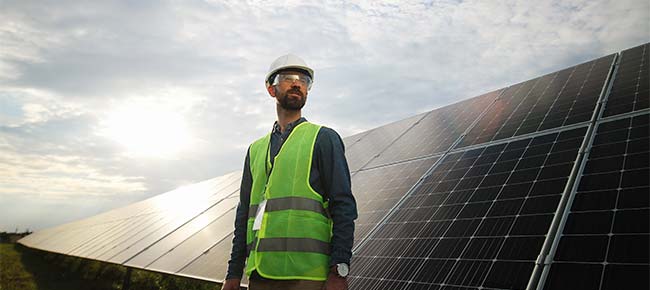 Engineer in proper safety attire at a solar farm